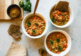 warming lentil turmeric soup in a bowl with coconut milk swirl and fresh herbs, anti-inflammatory lentil soup one pot 30 minutes with coconut milk and carrots, healing turmeric powder stirred into red lentil soup